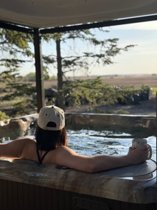 Person relaxing in a hot tub outdoors.