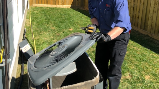 technician servicing an outdoor air conditioning unit